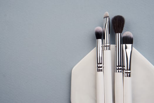 makeup brushes on gray background and stand cropped view Copy Space. High quality photo