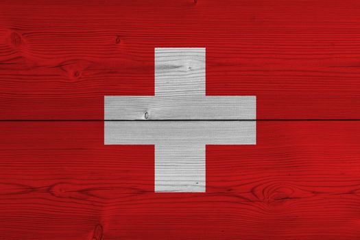 Switzerland flag painted on old wood plank. Patriotic background. National flag of Switzerland
