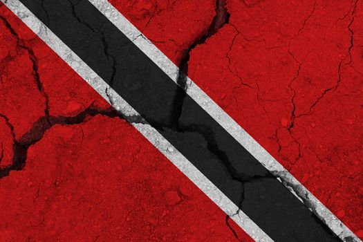 Trinidad and Tobago flag on the cracked earth. National flag of Trinidad and Tobago. Earthquake or drought concept