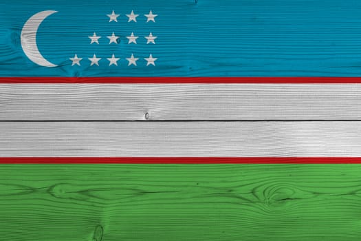 Uzbekistan flag painted on old wood plank. Patriotic background. National flag of Uzbekistan
