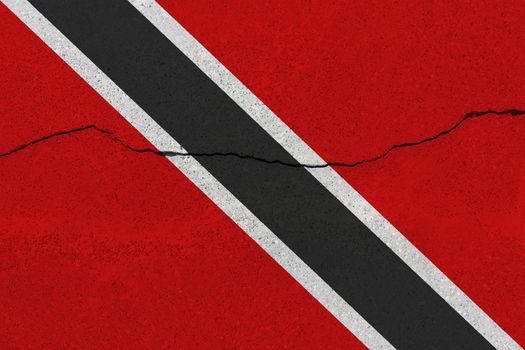 Trinidad and Tobago flag on concrete wall with crack. Patriotic grunge background. National flag of Trinidad and Tobago