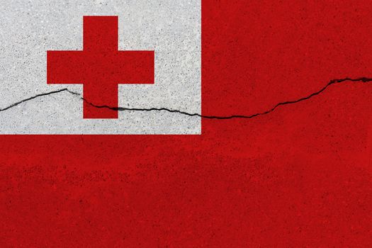 Tonga flag on concrete wall with crack. Patriotic grunge background. National flag of Tonga