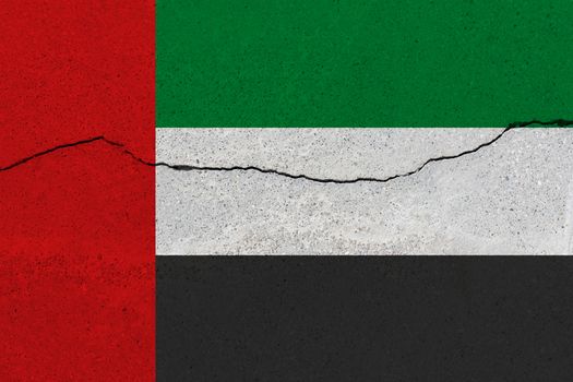 United arab flag on concrete wall with crack. Patriotic grunge background. National flag of United arab