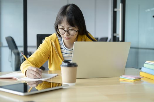 Young collage student using computer and mobile device studying online. Education and online learning. 