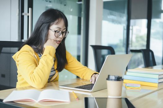 Young collage student using computer and mobile device studying online. Education and online learning. 