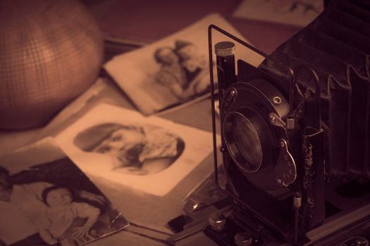 Old photos. Old camera on the background of photos. Toned photo. Photo album with photos from the last century.