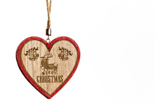 Hand holding heart shaped Christmas decoration isolated on white.