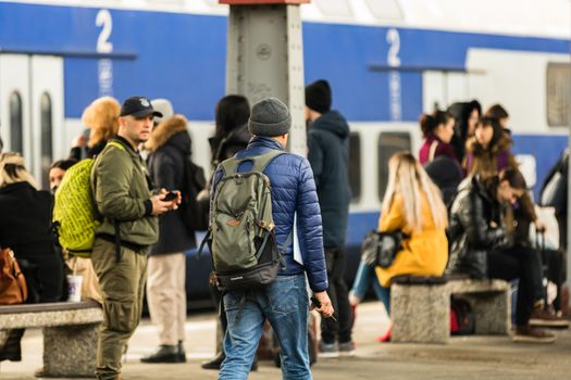 Travelers and commuters carry luggage and backpacks on the train platform of Bucharest North Railway Station (Gara de Nord Bucharest) in Bucharest, Romania, 2020