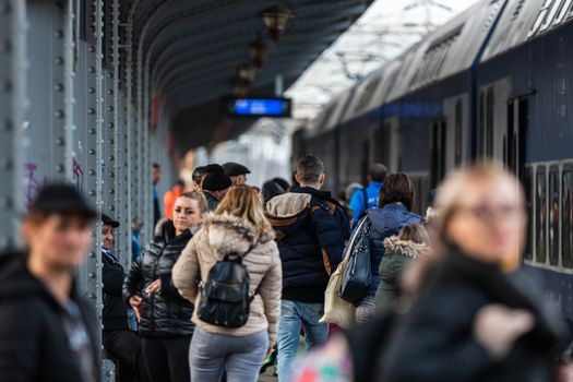 Travelers and commuters waiting for a train on the train platform of Bucharest North Railway Station (Gara de Nord Bucharest) in Bucharest, Romania, 2020