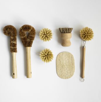 Set of brushes for eco-cleaning the home, washing dishes and surfaces without chemicals on a gray surface. Zero waste kitchen cleaning concept. Eco friendly natural cleaning bamboo dish brushes