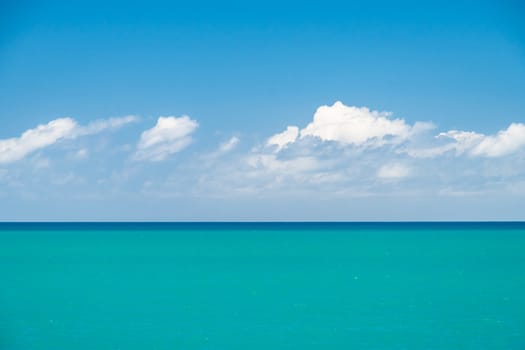 Minimalist image of the tropical ocean, the blue sky and white clouds