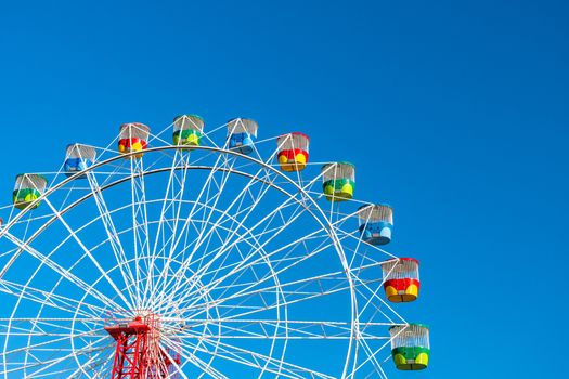 Ferris wheel with colourful rainbow seats in Sydney on clear blue sky background