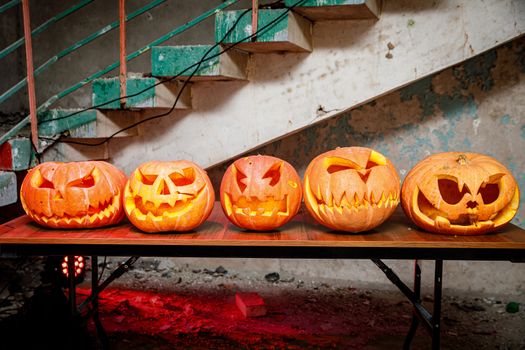 Row of pumpkins for Halloween on wooden table