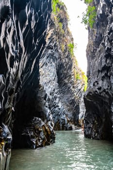 View of basalt rocks, waterfalls and pristine water of Alcantara gorges in Sicily, Italy