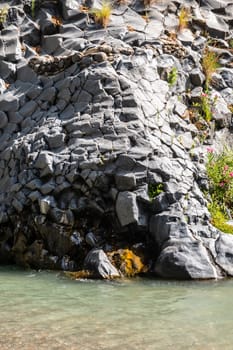 View of basalt rocks, waterfalls and pristine water of Alcantara gorges in Sicily, Italy