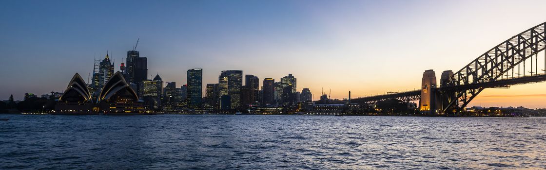Panoramic view of Sydney bay at sunset from Harbour bridge to the Opera House and the CBD