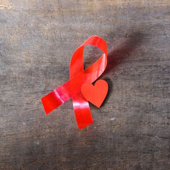 Red Ribbon Support HIV, AIDS and red Heart on wooden background and copy space for use