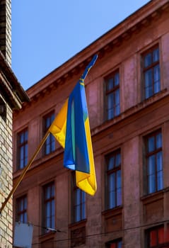 Ukrainian yellow blue flag waving on a flagpole of the building.