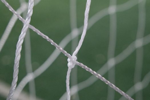 Night view of a soccer goal net under flood lights. Closeup view of goal net in a soccer playground