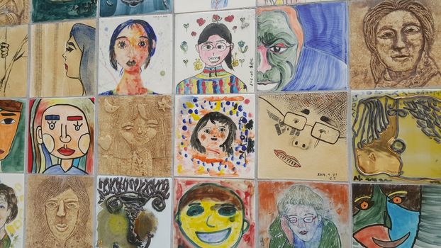 Chuncheon city hall, South Korea-March-25, 2019: Paintings and sculpted faces of people on the concrete wall for memoir in a public park.