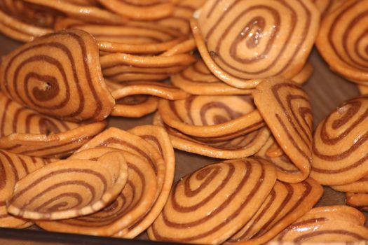 Closeup view with selective focus of a large number of round cookies with coconut filling lines.