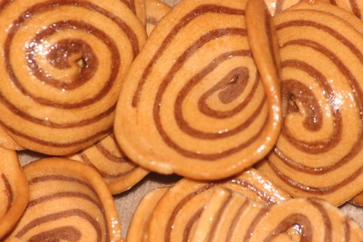 Closeup view with selective focus of a large number of round cookies with coconut filling lines.