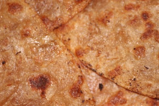 Traditional paratha - Macro closeup with selective focus of homemade oily bread or parotta. Chapati is traditional food of southeast Asia.