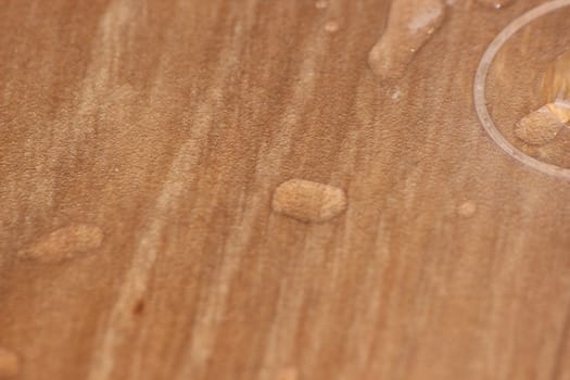 Closeup selective focus view of water drops on wooden floor. Abstract raindrops pattern on wooden board