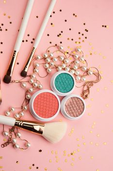 Eyeshadows and makeup brushes on a pink background Copy Space top view. High quality photo