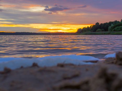 Panoramic view of evening sunset lake with green trees, mist and tranquil reflection. Estonia, Harku. Sunset over lake