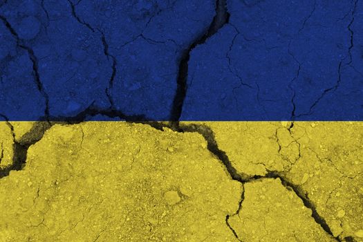 Ukraine flag on the cracked earth. National flag of Ukraine. Earthquake or drought concept