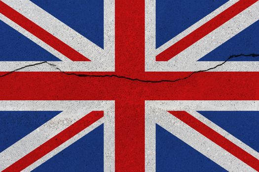 United Kingdom flag on concrete wall with crack. Patriotic grunge background. National flag of United Kingdom