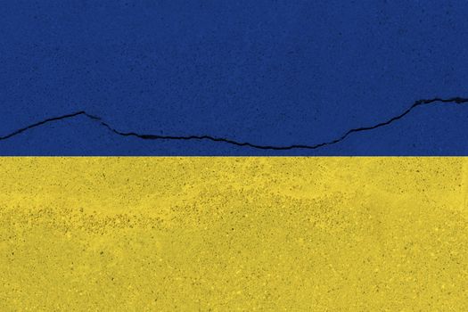 Ukraine flag on concrete wall with crack. Patriotic grunge background. National flag of Ukraine