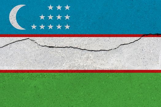 Uzbekistan flag on concrete wall with crack. Patriotic grunge background. National flag of Uzbekistan