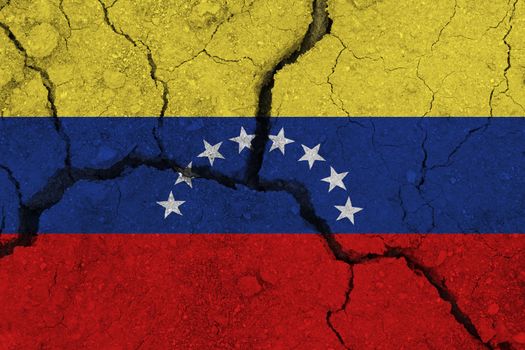 Venezuela flag on the cracked earth. National flag of Venezuela. Earthquake or drought concept