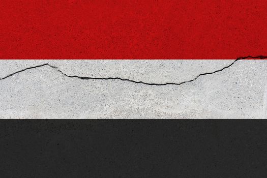Yemen flag on concrete wall with crack. Patriotic grunge background. National flag of Yemen