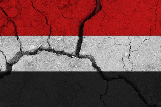 Yemen flag on the cracked earth. National flag of Yemen. Earthquake or drought concept