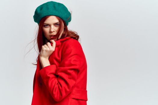 Woman in red coat and in green hat on isolated background cropped model with Copy Space emotions. High quality photo