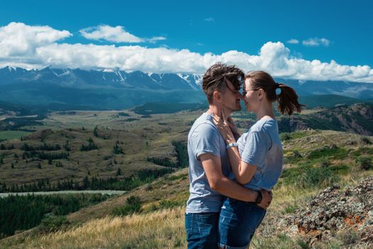 Loving couple together on Altai mountain looking at a view