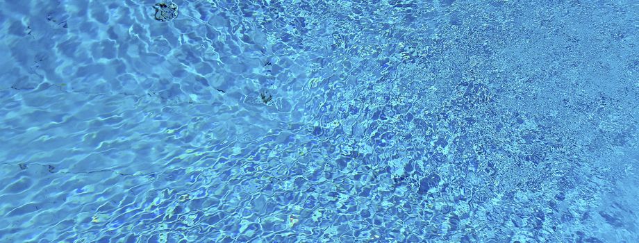 Blue water surface and ripple wave in swimming pool, may be used as background