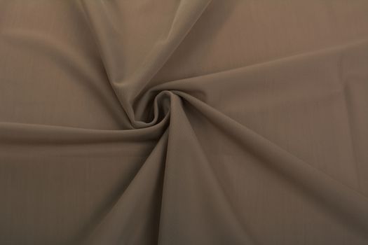 beige brown Knitted elastic fabric, weaving of threads texture, curl crumpled fold. For underwear, sports clothes and swimwear. Space for text.