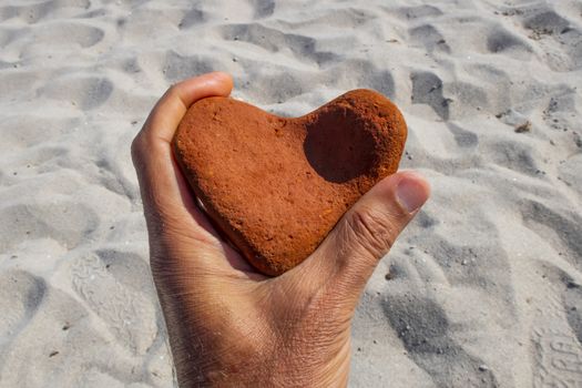 orange heart shaped stone at the beach