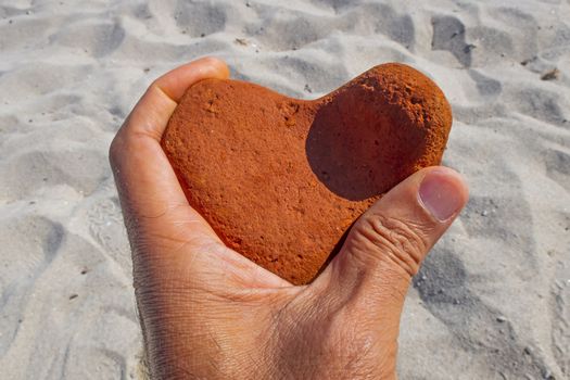 orange heart shaped stone at the beach