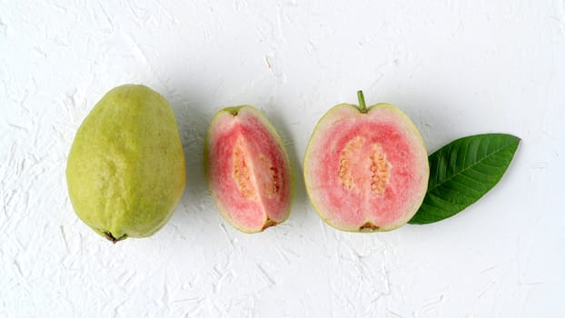 Top view, flat lay of delicious beautiful Red guava with fresh green leaves isolated on white table background, studio overhead table shot with copy space.