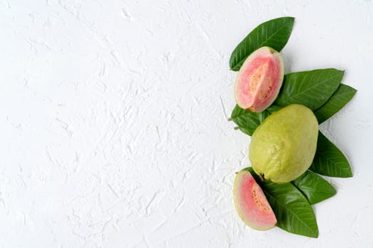 Top view, flat lay of delicious beautiful Red guava with fresh green leaves isolated on white table background, studio overhead table shot with copy space.