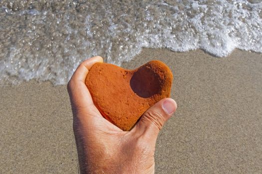 orange heart shaped stone at the beach