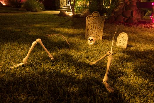 Illuminated home garden with skeleton and grave stone