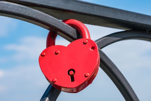 Lovers hang the lock on the railing of the bridge after the wedding