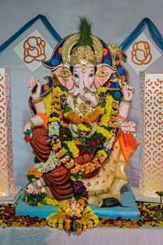 Portrait , closeup view of decorated and garlanded idol of Hindu God Ganesha in Pune, India.