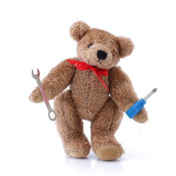 A Handy Teddy bear with tools screwdriver spanner on white
